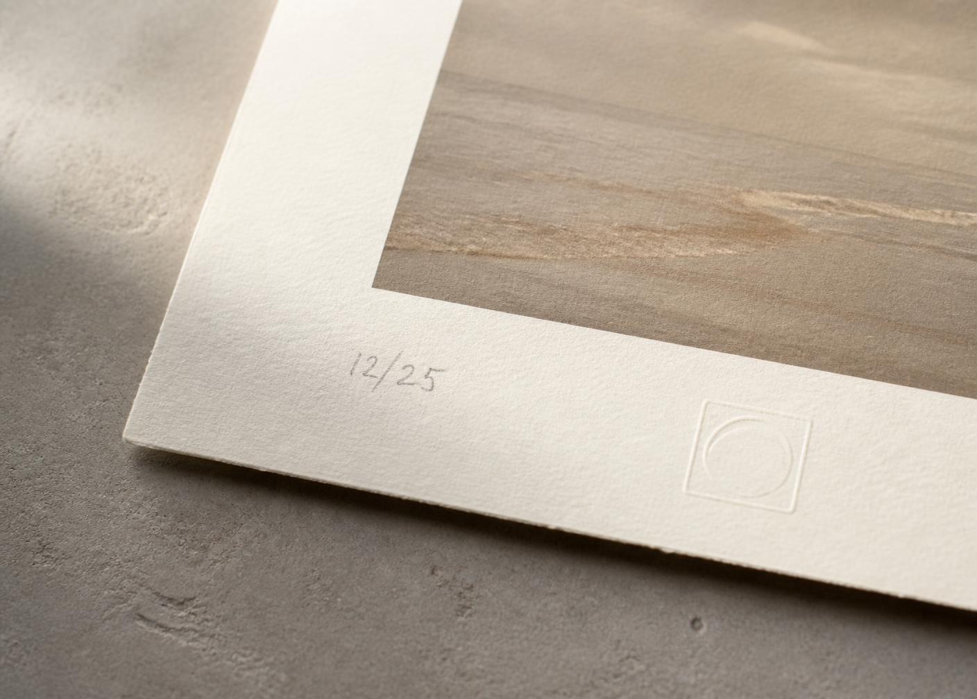 Corner of a fine-art pigment print showing the paper edge, a pencil edition mark and a subtle blind emboss